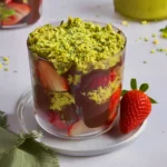 Dubai chocolate strawberries layered with chocolate and pistachio in a glass cup